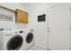 Bright laundry room with washer, dryer, and cabinets at 12333 W Fetlock Trl, Peoria, AZ 85383