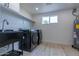 Laundry room with washer, dryer, sink, and ample shelving at 1644 W Thunderbird Rd, Phoenix, AZ 85023