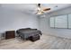 This bedroom offers tile flooring, a modern ceiling fan, neutral paint, and a large window at 1699 E Hearne Way, Gilbert, AZ 85234