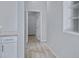 Bright hallway with wood-look tile flooring leading to an open door and a built-in shelving unit at 1699 E Hearne Way, Gilbert, AZ 85234