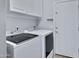 Well-equipped laundry room with modern washer and dryer, upper cabinets, and access to the exterior at 1699 E Hearne Way, Gilbert, AZ 85234