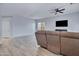 Spacious living room with tile floors, a ceiling fan, and a comfortable brown sofa at 1699 E Hearne Way, Gilbert, AZ 85234