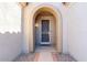 Front entry with arched doorway and security door at 18747 N Sunsites Dr, Surprise, AZ 85387