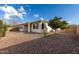 This is a view of the backyard, landscaped with rock, and featuring an orange tree at 18906 E Cattle Dr, Queen Creek, AZ 85142