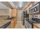 Modern kitchen with stainless steel appliances, tile floors, and granite countertops at 2025 E Campbell Ave # 140, Phoenix, AZ 85016