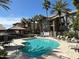 Community pool with surrounding lounge chairs and patio tables at 2025 E Campbell Ave # 140, Phoenix, AZ 85016