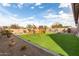 View of a backyard featuring artificial turf, desert landscaping, and a playset for outdoor activities at 21716 E Waverly Dr, Queen Creek, AZ 85142