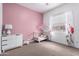 Bright bedroom featuring a crib, soft carpet, and a colorful accent wall at 21716 E Waverly Dr, Queen Creek, AZ 85142