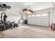 View of garage with overhead storage platform, a modern motorbike, and white garage doors with windows at 21716 E Waverly Dr, Queen Creek, AZ 85142