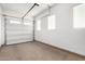 View of an empty garage with bright lights, white walls, and a garage door with window inlays at 21716 E Waverly Dr, Queen Creek, AZ 85142
