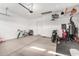View of a large, well-organized garage with a bicycle, motorbike, and plenty of space for storage and activities at 21716 E Waverly Dr, Queen Creek, AZ 85142