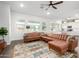 Inviting living room featuring a large leather sectional sofa, colorful rug, and abundant natural light at 21716 E Waverly Dr, Queen Creek, AZ 85142