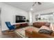 Spacious living room features a leather sectional, rocking chair, modern rug, and lots of natural light at 21716 E Waverly Dr, Queen Creek, AZ 85142
