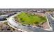 An aerial view of a neighborhood park with green grass and a walking path winding through a park at 21716 E Waverly Dr, Queen Creek, AZ 85142