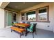 Covered patio featuring outdoor dining area, a wooden table with chairs, a bench, and views of the exterior at 21716 E Waverly Dr, Queen Creek, AZ 85142