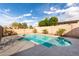 Backyard swimming pool surrounded by desert landscaping, a brick wall, and palm trees under a blue sky at 21716 E Waverly Dr, Queen Creek, AZ 85142