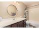 Cozy bathroom features a round mirror, a single sink vanity, and a shower-tub combination with printed shower curtain at 2715 W Calle Del Norte Dr, Chandler, AZ 85224