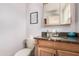 Bathroom showcasing a granite countertop, wood cabinets, a decorative mirror, and a comfort height toilet at 2715 W Calle Del Norte Dr, Chandler, AZ 85224