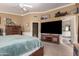 Comfortable bedroom has carpeted floors, TV, an armoire, and a bathroom ensuite at 2715 W Calle Del Norte Dr, Chandler, AZ 85224
