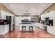 Spacious kitchen featuring white cabinets, stainless steel appliances, and a center island with bar stool seating at 2715 W Calle Del Norte Dr, Chandler, AZ 85224