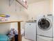 Functional laundry room with shelving, washer, dryer and folding table for efficient laundry management at 2715 W Calle Del Norte Dr, Chandler, AZ 85224