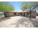 Beautiful single-story home with a circular driveway, mature trees, and desert landscaping at 2949 E Willow Ave, Phoenix, AZ 85032