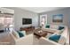 Spacious living room featuring comfortable sofas, a large TV, and hardwood floors at 2949 E Willow Ave, Phoenix, AZ 85032