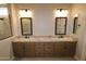 Bathroom featuring granite countertops, double sinks, and framed mirrors at 32464 N 134Th Ln, Peoria, AZ 85383
