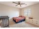 Bedroom with crib, bed, dresser, and ceiling fan at 32504 N Cherry Creek Rd, San Tan Valley, AZ 85144