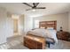 Main bedroom with wooden headboard, ceiling fan, and ensuite bathroom at 32504 N Cherry Creek Rd, San Tan Valley, AZ 85144