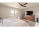 Bright bedroom with a dresser, large TV, and window with natural light at 32504 N Cherry Creek Rd, San Tan Valley, AZ 85144