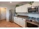 White kitchen with stainless steel appliances and dark countertops at 32504 N Cherry Creek Rd, San Tan Valley, AZ 85144