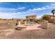 Inviting backyard featuring a custom firepit, built-in BBQ, dining area, and lush desert landscaping at 32504 N Cherry Creek Rd, San Tan Valley, AZ 85144