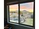 A backyard view from inside features a pool, desert landscape, trampoline and butte views at 32504 N Cherry Creek Rd, San Tan Valley, AZ 85144