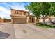 Charming two-story home with a tile roof, stone accents, a well-manicured lawn, and a spacious driveway at 32504 N Cherry Creek Rd, San Tan Valley, AZ 85144