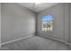Well-lit bedroom featuring an arched window and gray carpet at 4275 E Bernice E St, Gilbert, AZ 85295