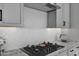Modern gas cooktop with granite countertops and white cabinets at 4275 E Bernice E St, Gilbert, AZ 85295