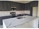 Modern kitchen with dark cabinetry, marble countertops, and stainless steel appliances at 4841 S Vista Pl, Chandler, AZ 85248