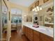 Main bathroom with double vanity, wood cabinets, and views to bedroom at 5450 E Mclellan Rd # 215, Mesa, AZ 85205