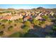 Panoramic aerial view of a residential area displaying homes with well-kept yards in a desert landscape, offering mountain vistas at 6616 W Side Canyon Trl, Phoenix, AZ 85083