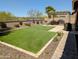 Backyard with artificial turf and a covered patio, perfect for relaxing and outdoor entertaining with mountain views in the background at 6616 W Side Canyon Trl, Phoenix, AZ 85083