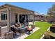 Backyard features an artificial lawn, paved patio, outdoor seating, and a gas firepit, ideal for outdoor living and relaxation at 6616 W Side Canyon Trl, Phoenix, AZ 85083
