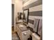 Powder room featuring stylish gray vanity and striped accent wall at 6616 W Side Canyon Trl, Phoenix, AZ 85083