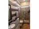 Bathroom with tiled shower, gray vanity, and striking horizontal striped accent wall at 6616 W Side Canyon Trl, Phoenix, AZ 85083