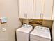 Laundry room features modern white cabinets above a washing machine and dryer with a decorative sign and access to smart technology at 6616 W Side Canyon Trl, Phoenix, AZ 85083