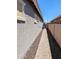 Side yard featuring a stone pathway with gravel landscaping, complemented by privacy fencing and home exterior at 6616 W Side Canyon Trl, Phoenix, AZ 85083