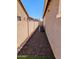 Side yard showcasing gravel landscaping, privacy fence, and an exterior A/C unit, enhancing the home's functionality and design at 6616 W Side Canyon Trl, Phoenix, AZ 85083