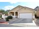 Tan house with white garage door and landscaping at 6657 E Regina St, Mesa, AZ 85215