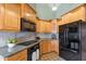 Kitchen with light wood cabinets, granite countertops, and black appliances at 7833 S Terrace Rd, Tempe, AZ 85284