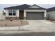 Charming single-story home featuring stone accents, a two-car garage, and low maintenance desert landscaping at 97 S Collier Ln, Casa Grande, AZ 85122